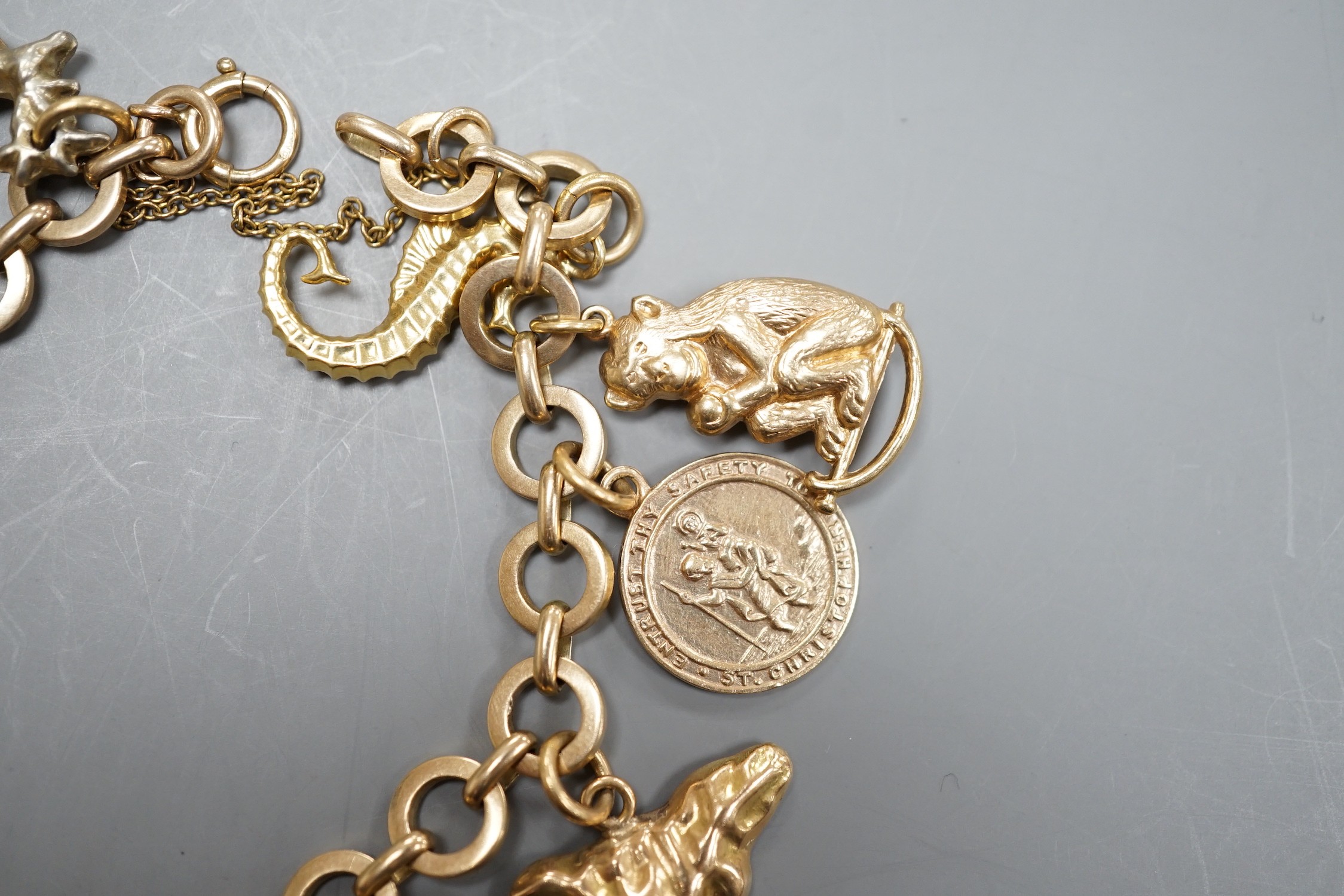 A 9ct gold charm bracelet, hung with assorted charm, including wagon, key, monkey etc. including six 9ct and one 18ct gold, gross weight 33.6 grams.